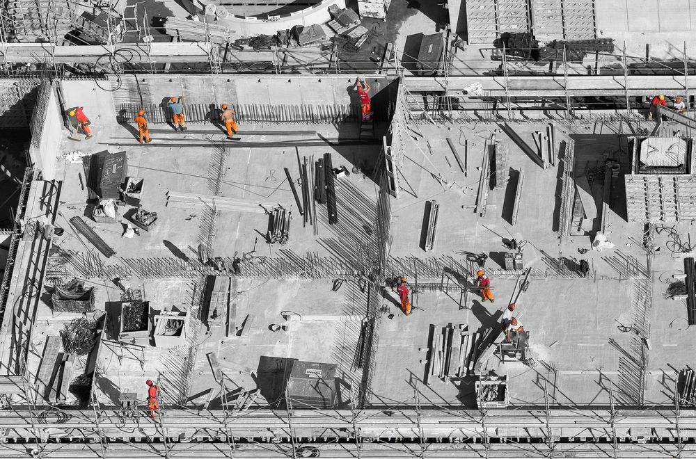 Aerial view of a construction site with engineers in high-visibility workwear.