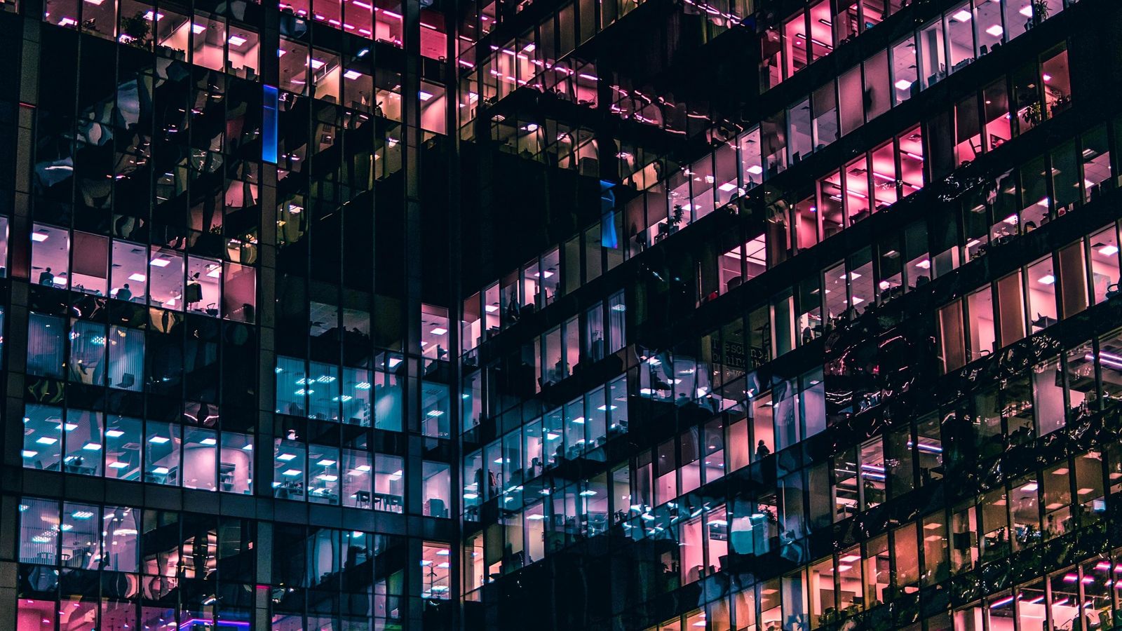 Office building at night with lit windows across many floors